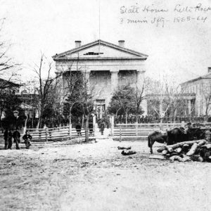 Soldiers lined up before classical structure "State House Little Rock Ark." with horses and packs in foreground