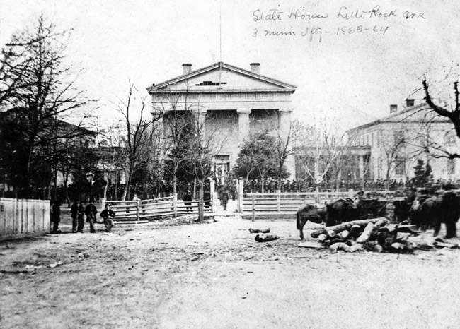 Soldiers lined up before classical structure "State House Little Rock Ark." with horses and packs in foreground