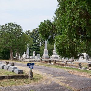 Cemetery roads with family plots, tall monuments, and trees