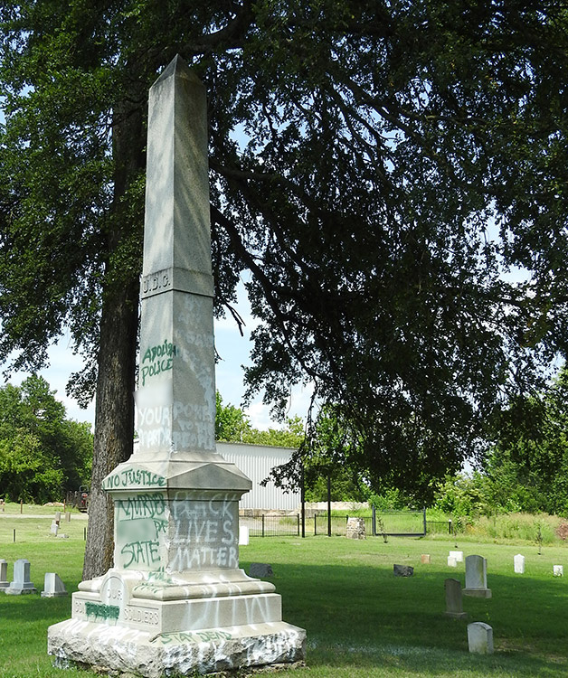 Spray painted obelisk monument in cemetery