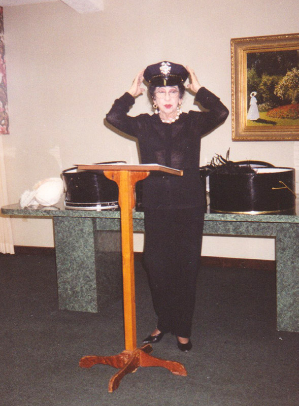 White woman trying on police hat behind lectern
