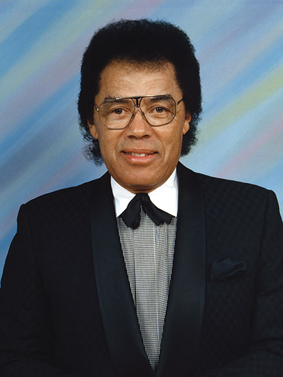 African-American man with glasses smiling in suit
