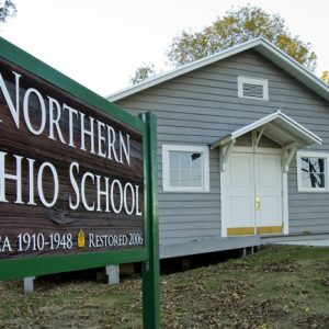 Single-story school house with sign "Northern Ohio School" and walking path