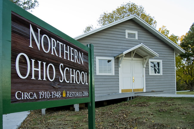 Single-story school house with sign "Northern Ohio School" and walking path