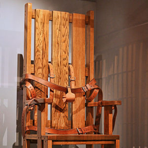 Wooden electric chair with leather straps on display