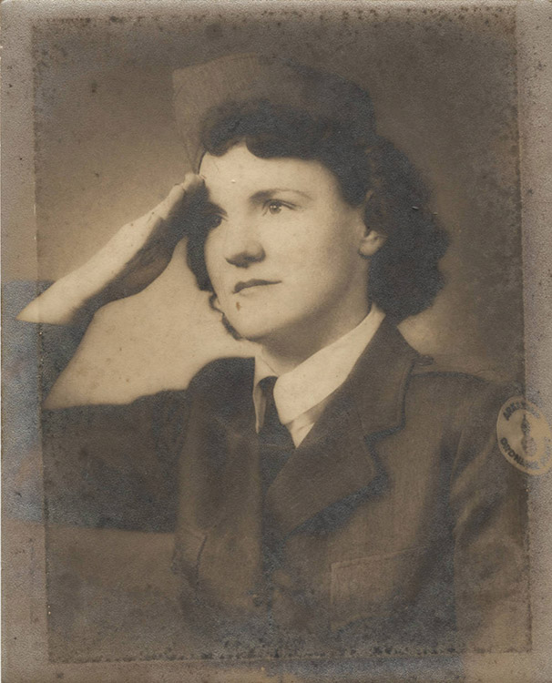 Young white woman in military uniform doing a salute with her right hand