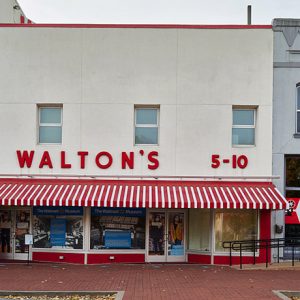 "Walton's" storefront building with red and white striped awning over sidewalk