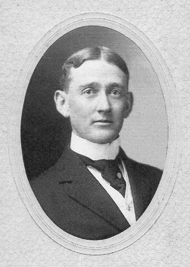 photo of white man in suit and tie in oval frame