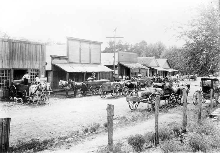 Street lined with buildings busy with wagons and car