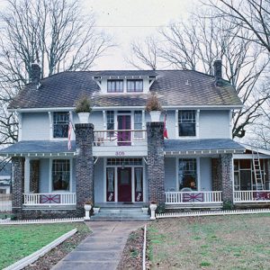 Three-story house with covered porch and twin columns with planters on top