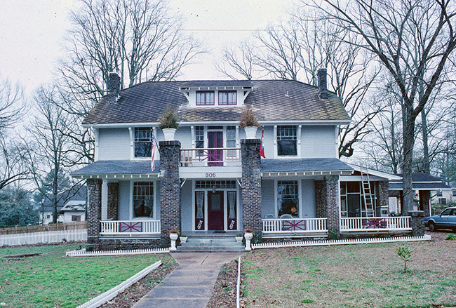 Three-story house with covered porch and twin columns with planters on top