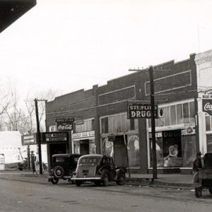 Street scene with storefronts and cars