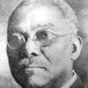 Older African-American man with mustache in suit and tie and glasses