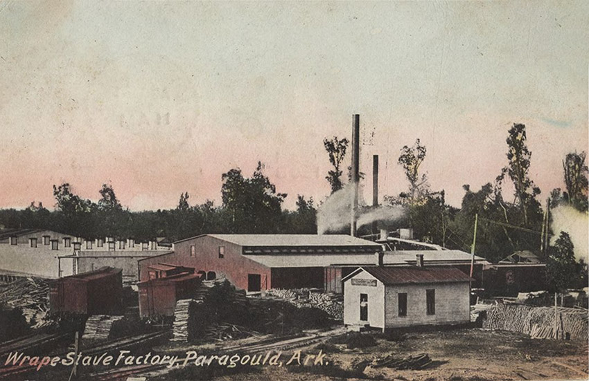 Factory buildings with smoke stacks and piles of lumber on post card