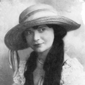 Young white woman with long hair in hat and dress