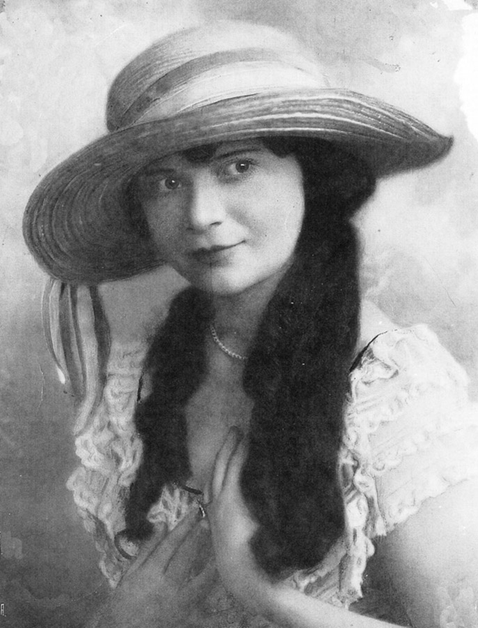 Young white woman with long hair in hat and dress