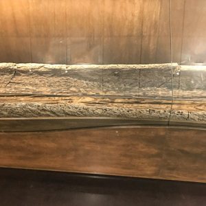 Middle section of wooden canoe in glass display case