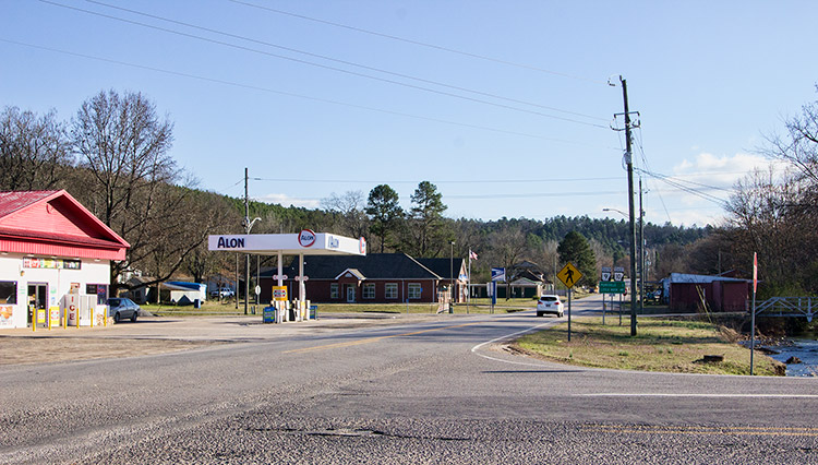 Gas station canopy and building on street with brick buildings in the background