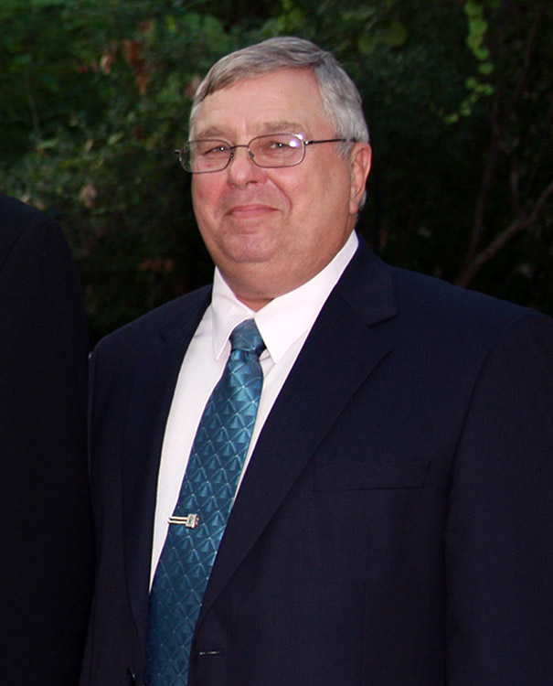 Older white man with glasses in suit and tie