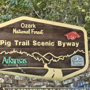 "Pig Trail Scenic Byway" sign with stone base