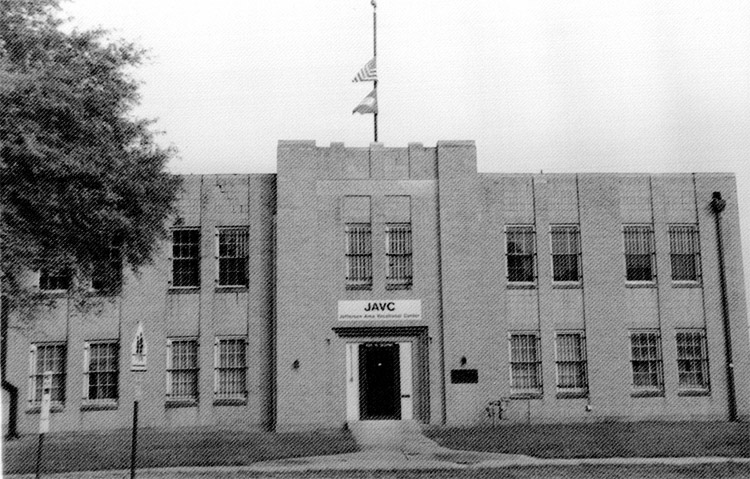Two-story "J.A.V.C." building with flag poles on top