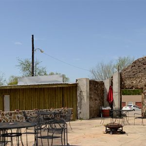 Outdoor eating area with stone wall and concrete entrance way