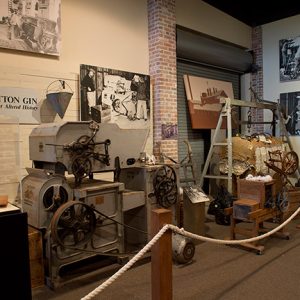 Cotton gin machinery on display in museum behind rope