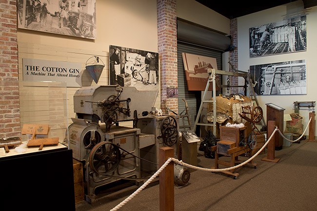 Cotton gin machinery on display in museum behind rope