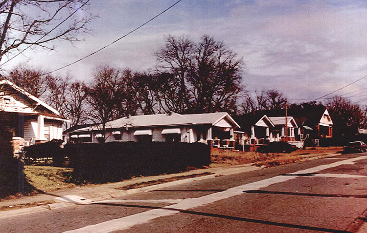Row of carpenter style houses with covered porches on street