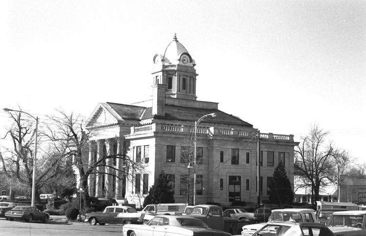 Two-story courthouse with dome clock tower and four columns