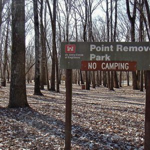 "Point remove park no camping" sign with trees behind it