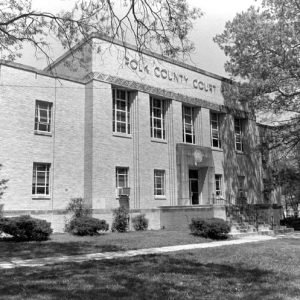 Two-story brick building "Polk County Court House" with tree and street lamp