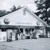 White man and woman outside gas station and general store "Possum Grape Mercantile"