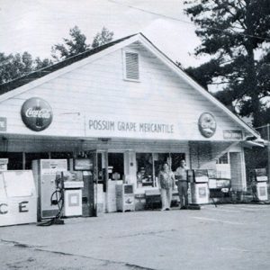 White man and woman outside gas station and general store "Possum Grape Mercantile"