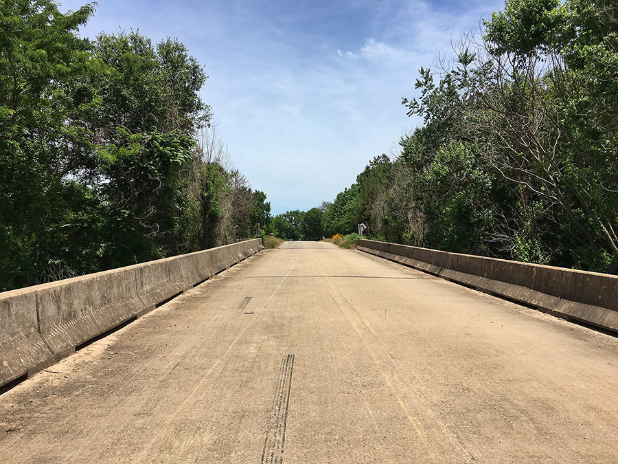 View from upon concrete bridge looking towards with concrete railing