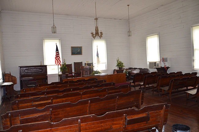 Church sanctuary with wooden pews desk and piano