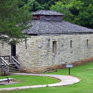 Stone jail building with narrow windows, walkway and wooden steps