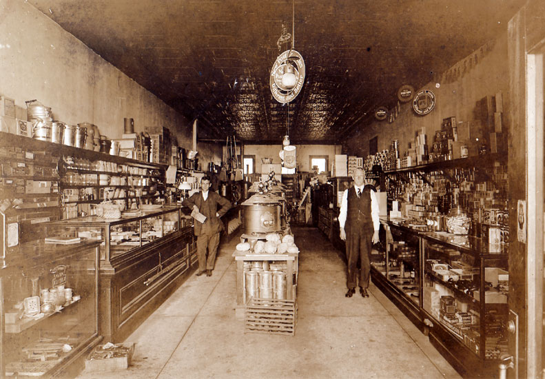 White men in suit and tie in store with items in glass cases