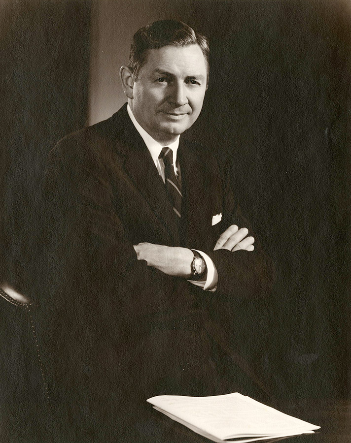 White man smiling in suit and striped tie