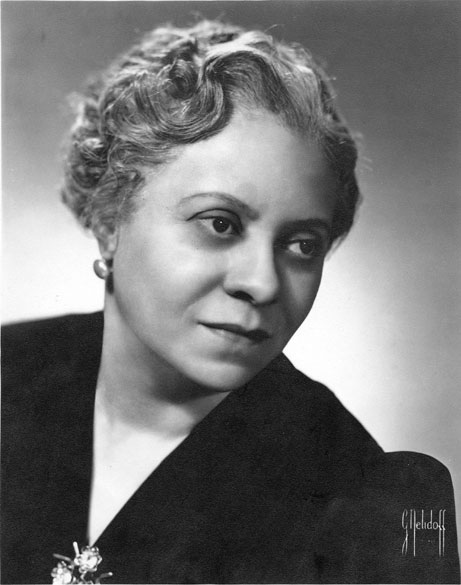 African-American woman with curly hair and earrings in a dress