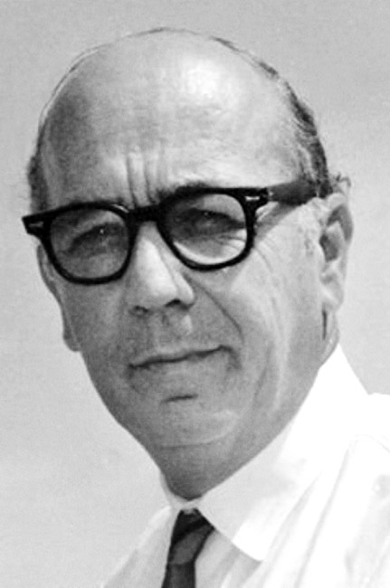 White man in black framed glasses in shirt and tie