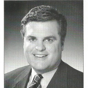 Large white man smiling in suit and tie on campaign literature