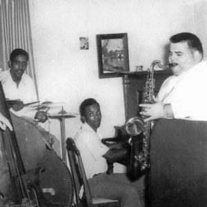 Two African-American and two white musicians playing their instruments in room