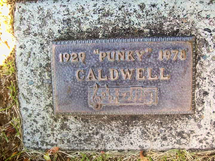 Plaque on stone grave marker with inscription and music staff with notes below it
