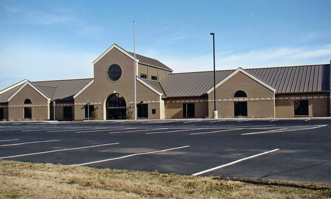 Concrete building with skylight and arched entrance on empty parking lot