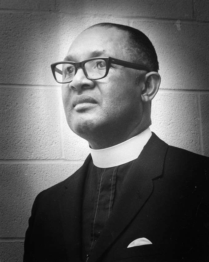 African-American man with glasses in suit with white collar