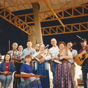 Group of white musicians with their instruments on outdoor stage