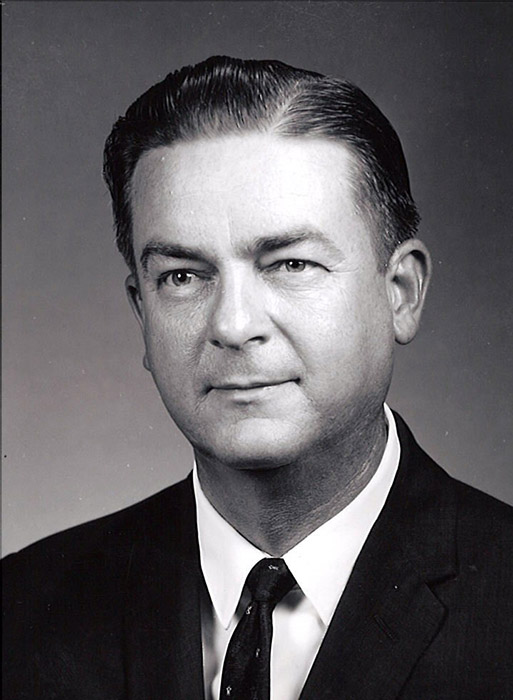 White man grinning in suit and tie