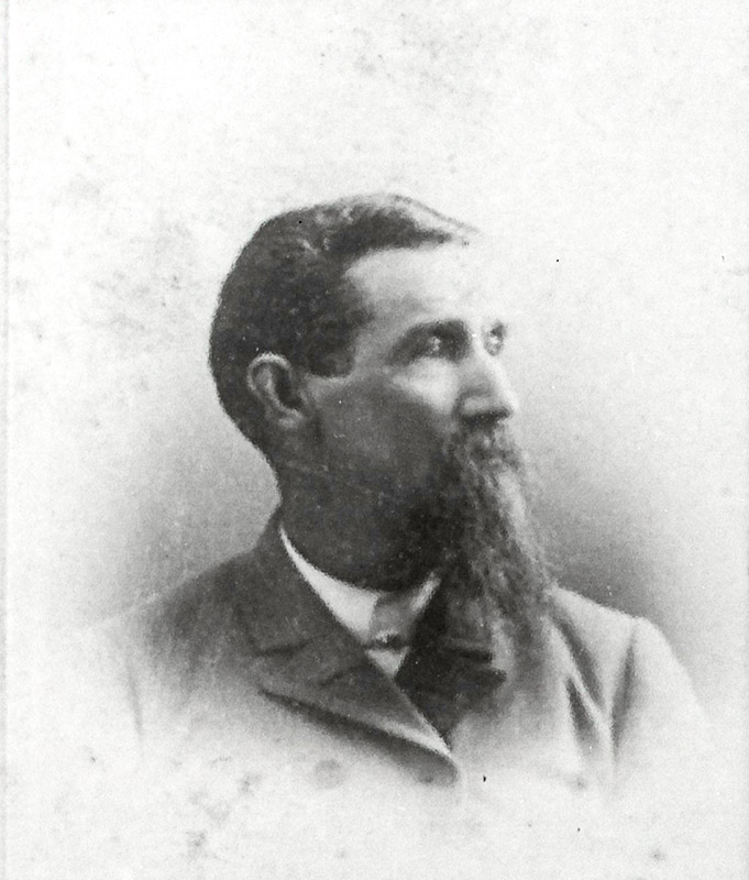 White man with long beard in suit and tie