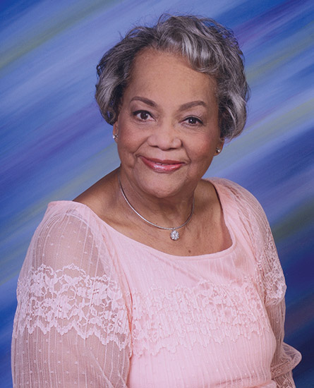 Older African-American woman smiling in pink dress
